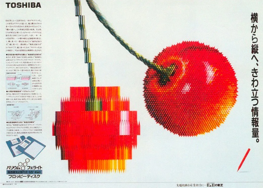 Toshiba advertisement with a pixelated red cherry on the left and a photographic cherry on the right.